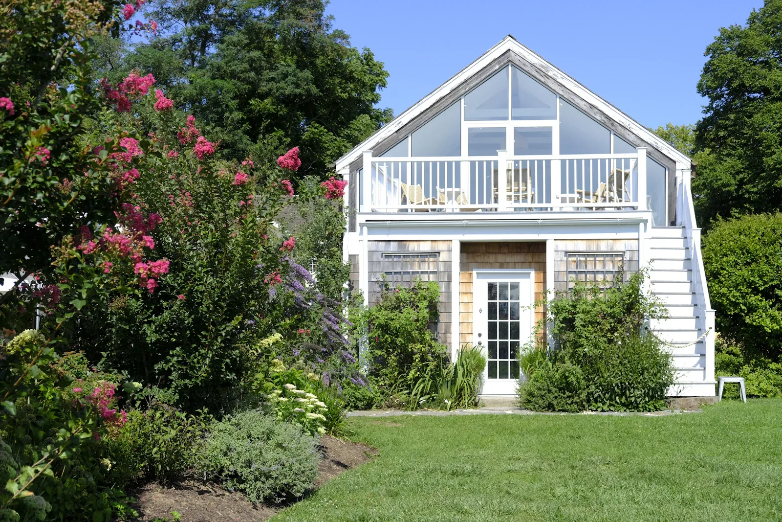A small detached single-story dwelling with a covered porch and its own deck