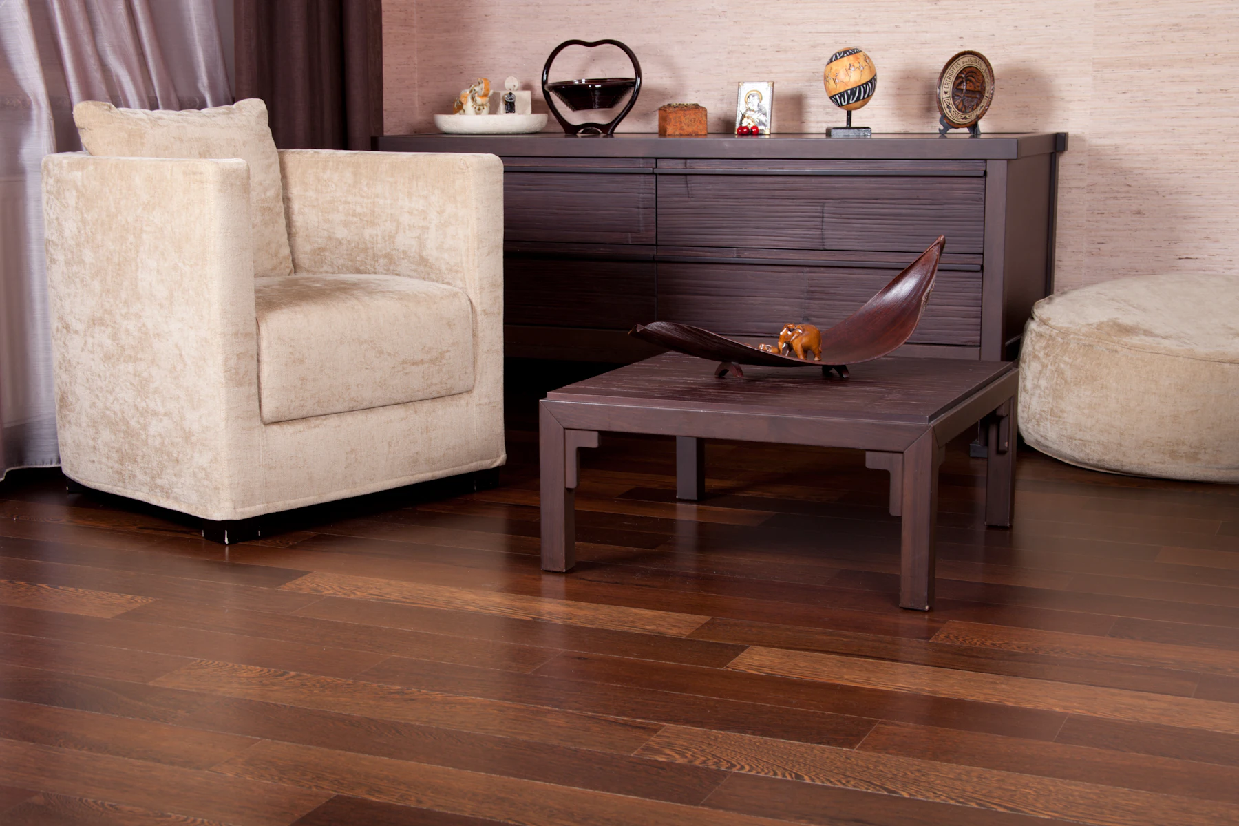 A finished living room with warm timber flooring running the length of the space