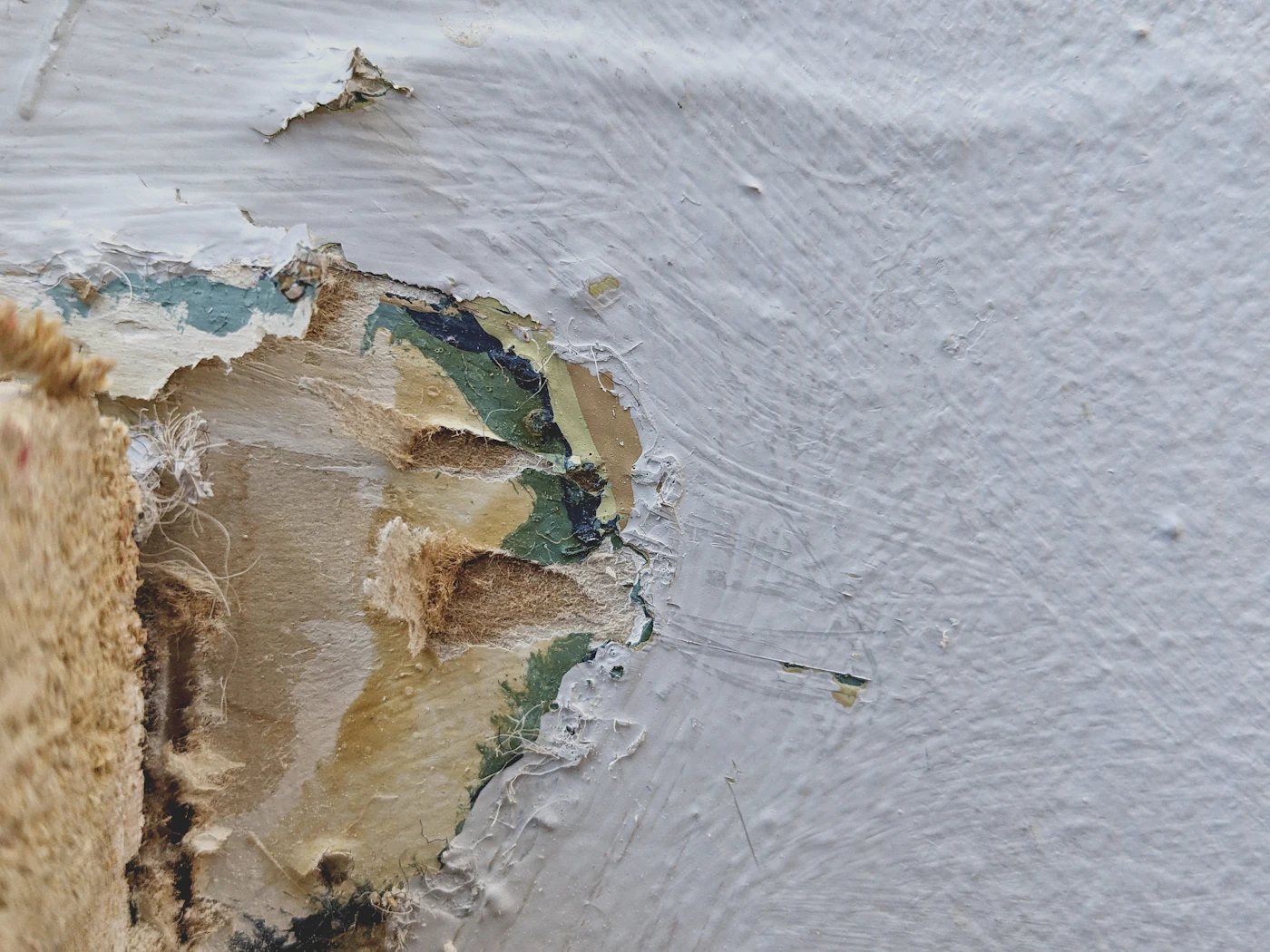 A close view of a wall where paint has blistered and lifted away from the substrate