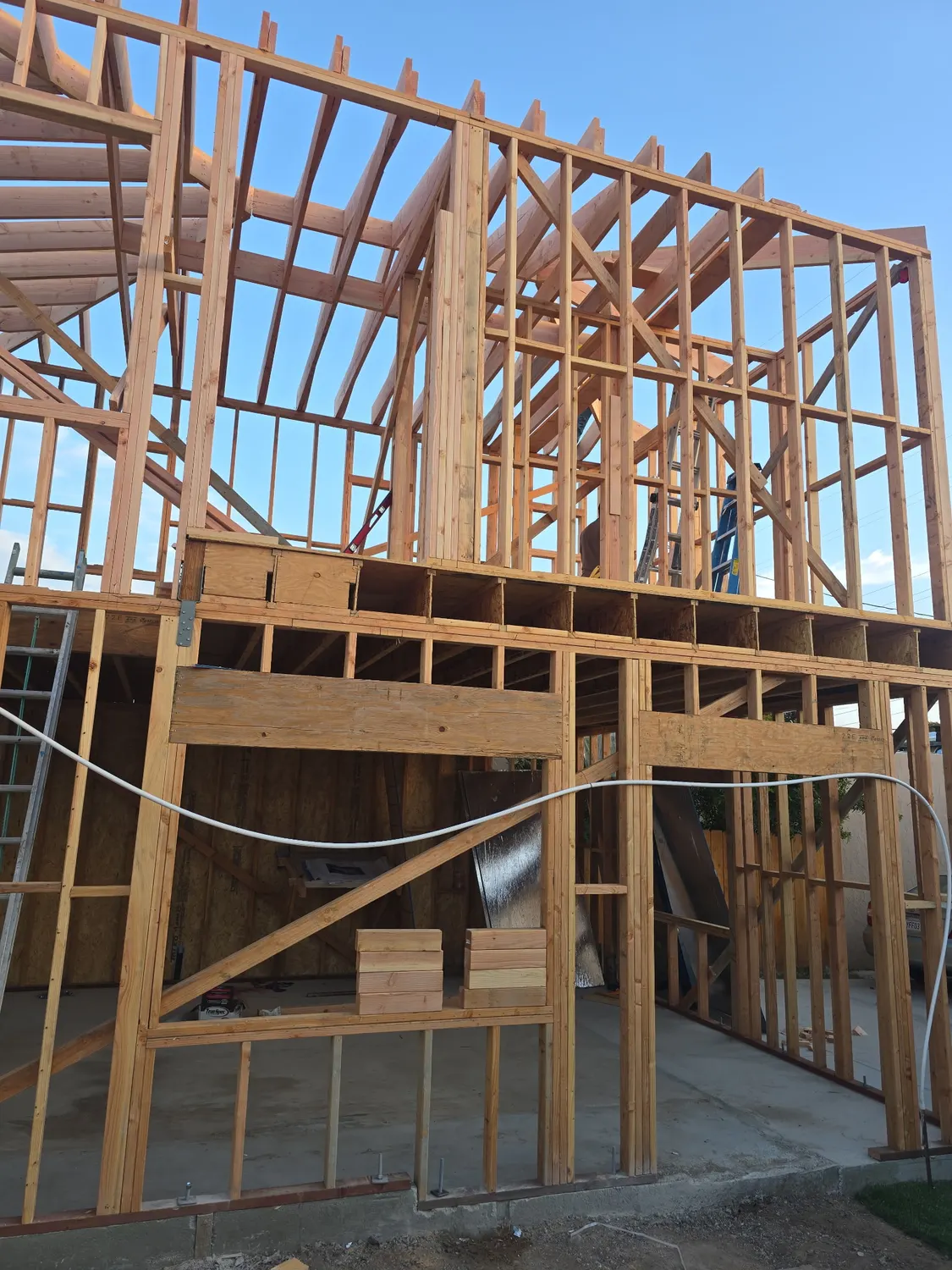 A two-story unit with the upper floor and roof rafters framed out and the structure open to the sky