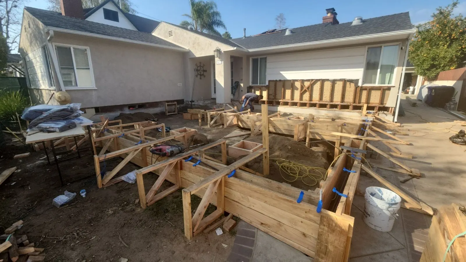 Timber formwork and bracing set out across a rear yard ready for a foundation pour